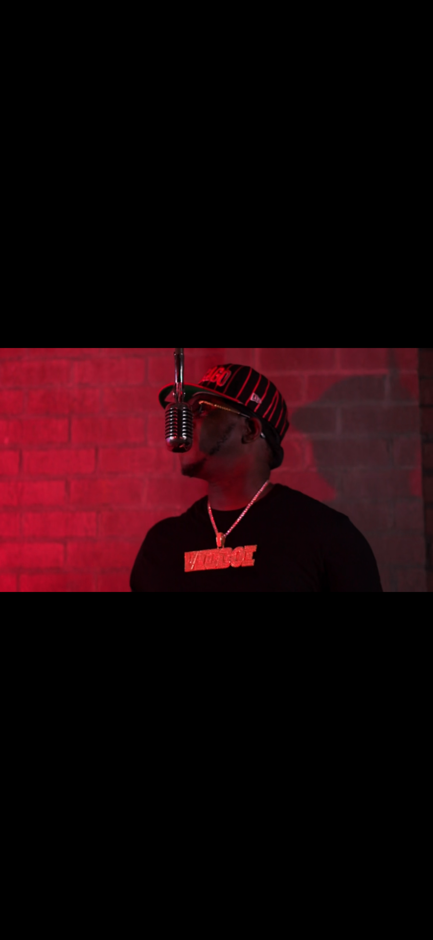 Vicboi_PainMusiq at the microphone, washed in red light